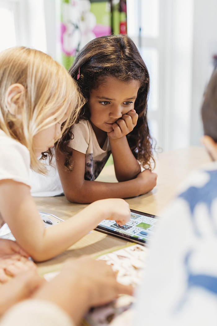 kindergarten-readiness Young children looking at books on a table.