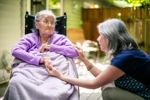 Patient sitting outside of her home with an in-home medical care professional