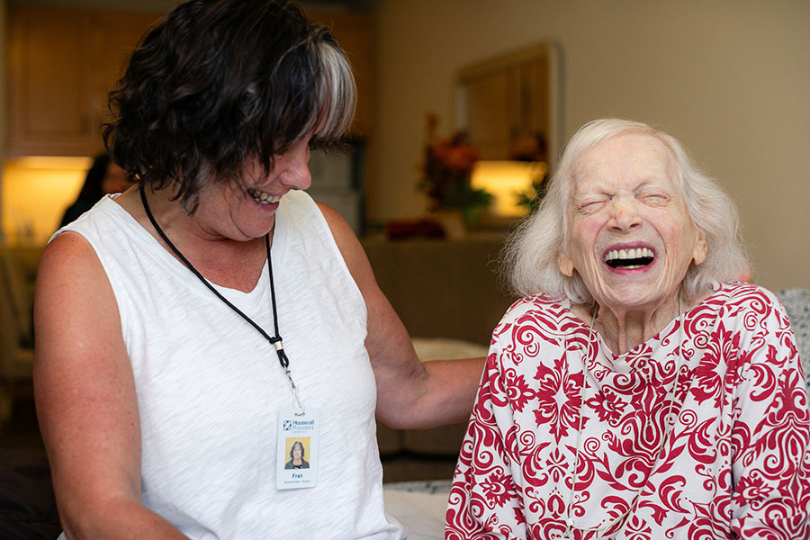 A Housecall Providers Hospice patient laughs during a visit with her care team