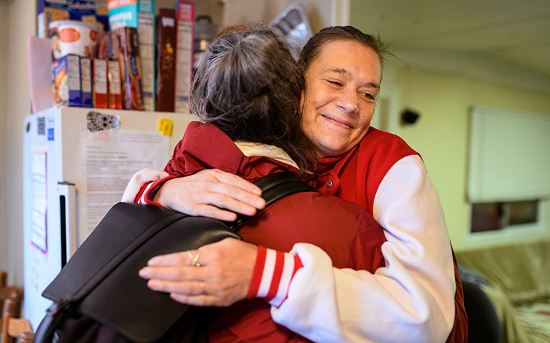 Health care professional and patient hug during a house call